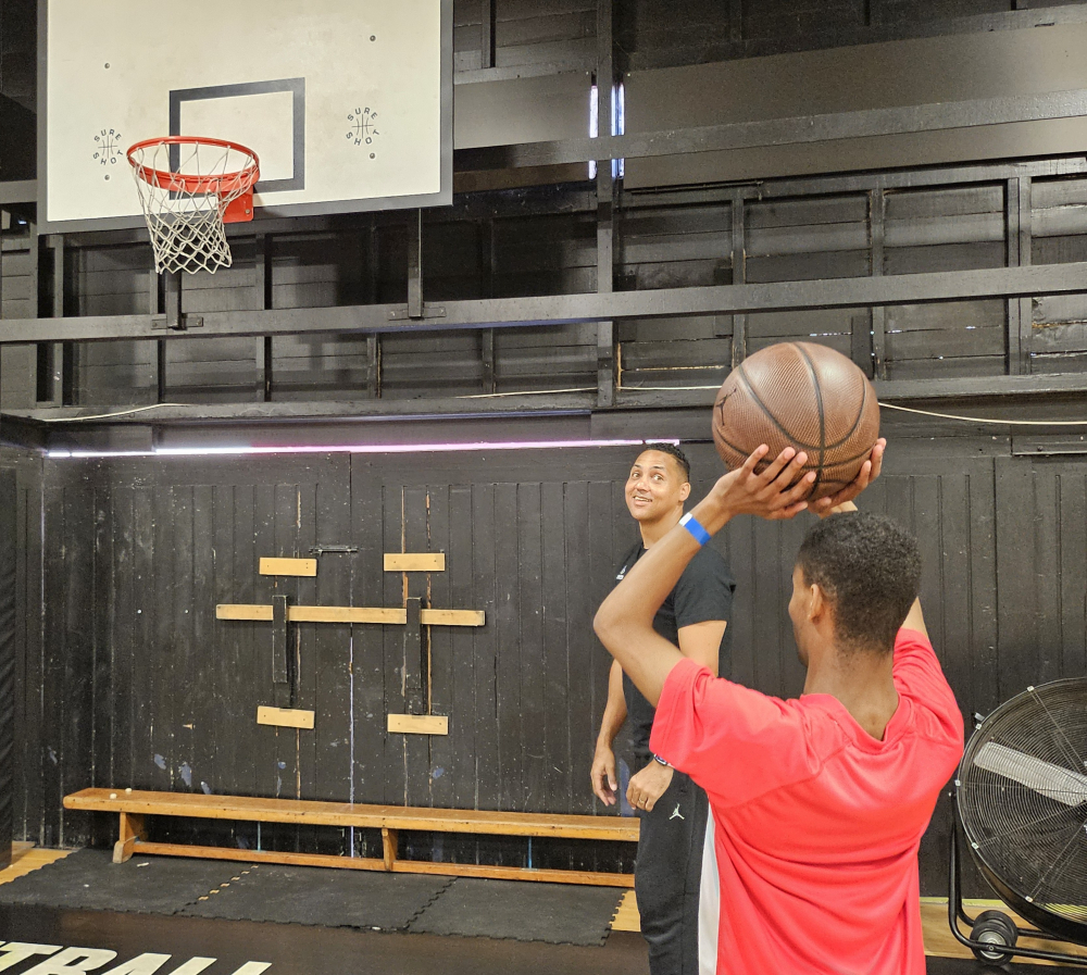 A man stands with a basketball in his hands about to shoot a hoop