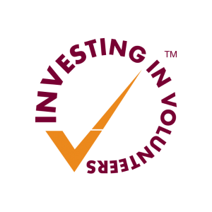 Logo for Investing in Volunteers, purple text on orange tick