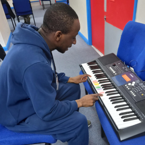 A man sits and plays at a keyboard