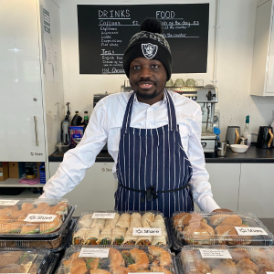 A man stands over a selection of packaged up foods for a catering event