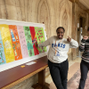 Sahra and Kelly stand with thumbs up in front of their artwork