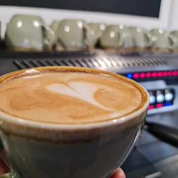 Close up of a latte with froth art and a coffee machine in the background