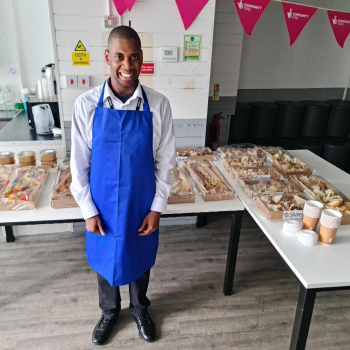 A man stands next to an array of food prepared for an event