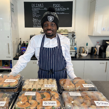 A man stands proudly next to a selection of packaged food he's just prepared