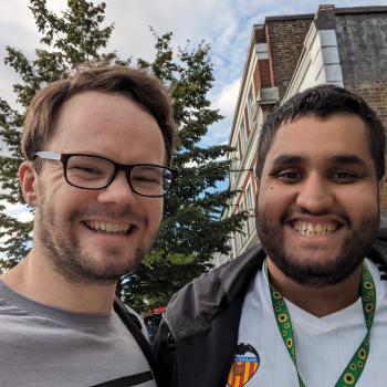 Two men take a selfie smiling at the camera