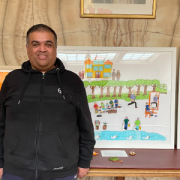 Student Rehan stands proudly next to his colourful artwork depicting a harmonious park scene